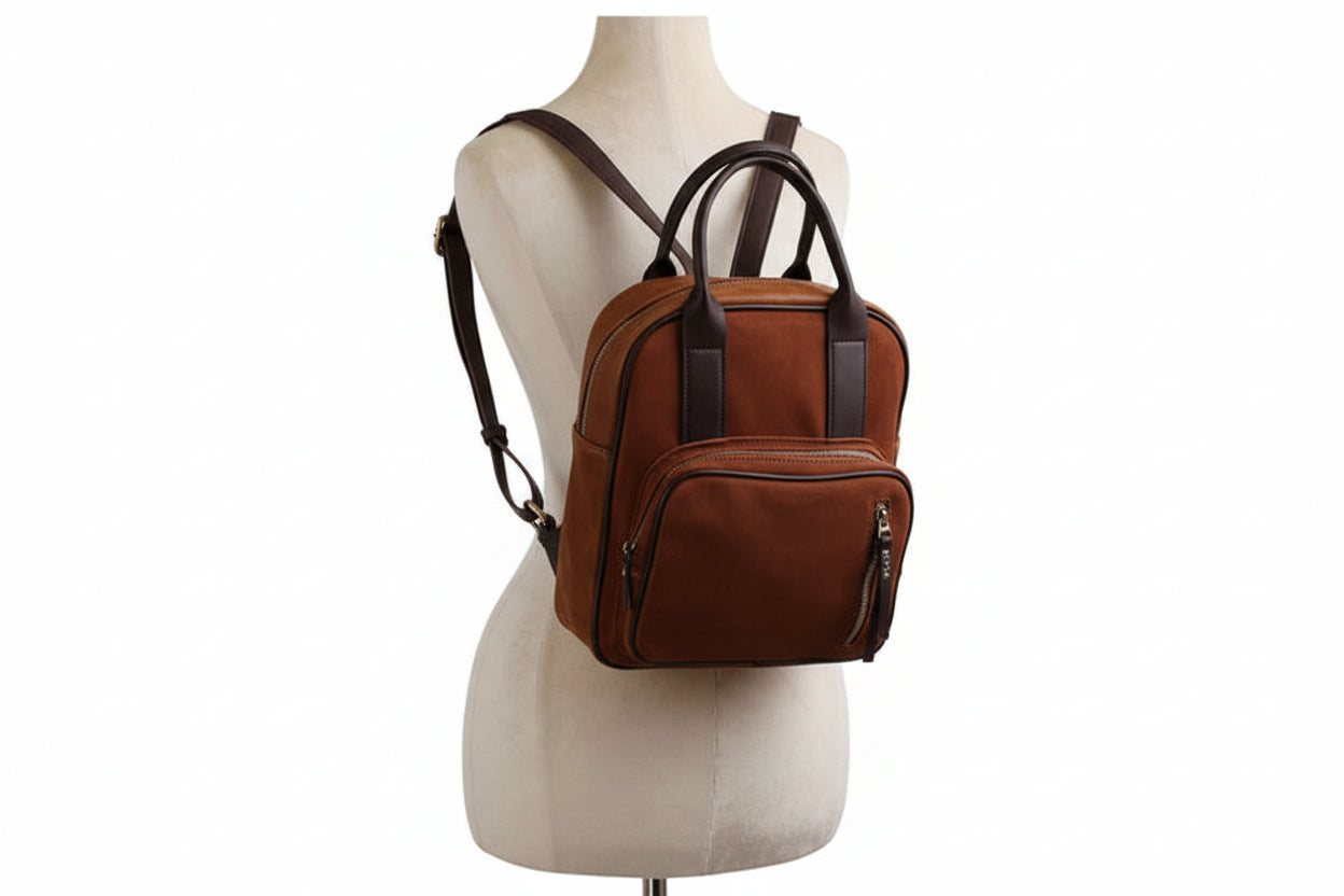 Brown leather backpack on a mannequin bust against a white background