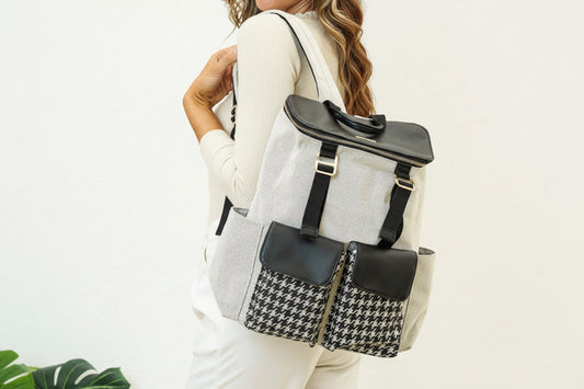 Woman carrying a gray backpack with a black and white patterned pocket on a white background