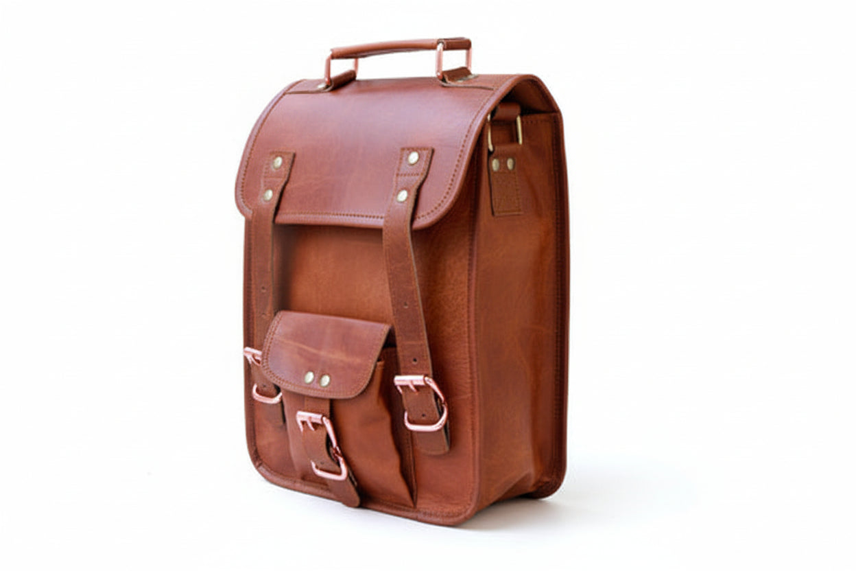 Brown leather backpack with gold buckles on a white background