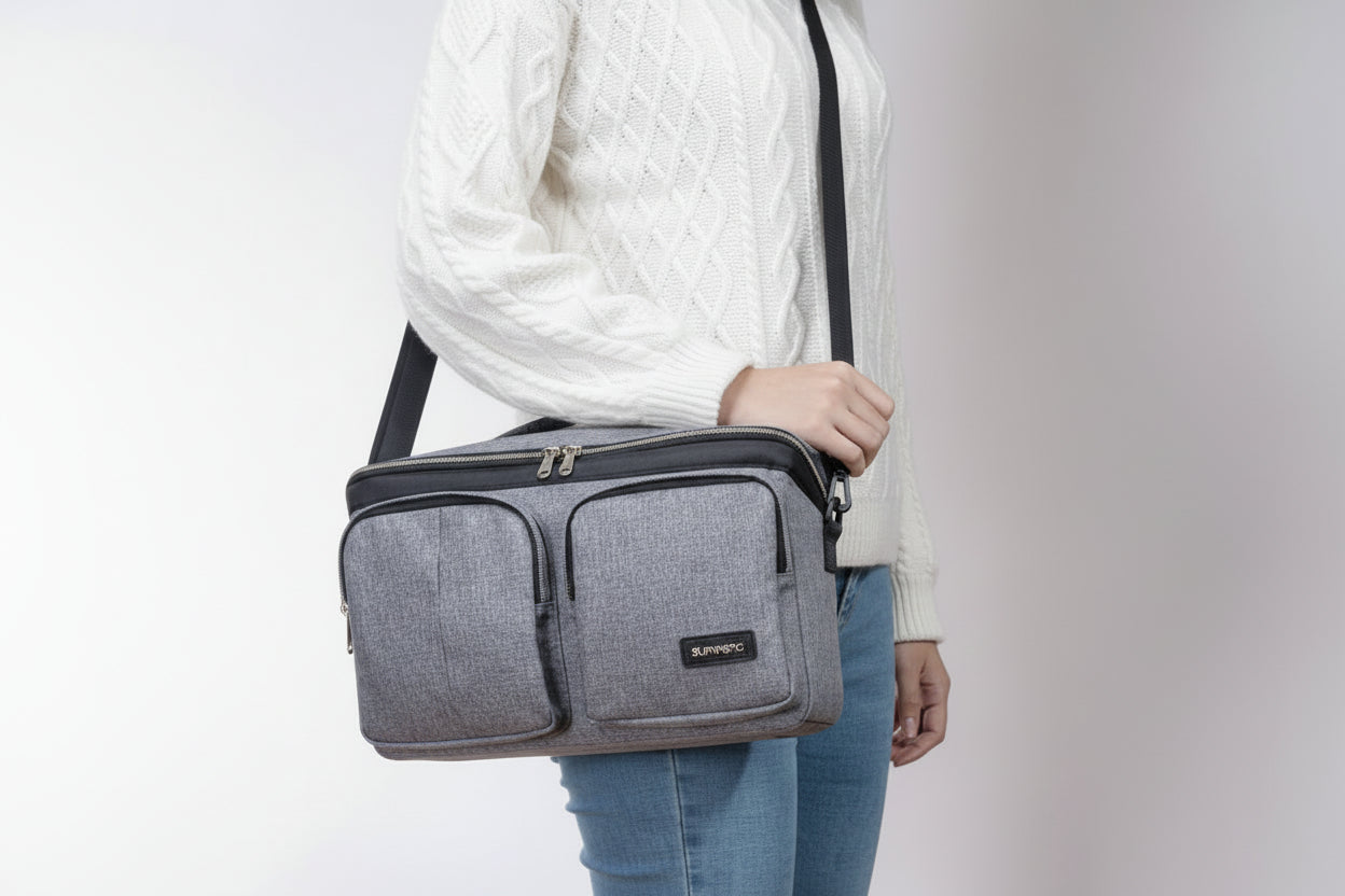 Person holding a gray crossbody bag with a plain background